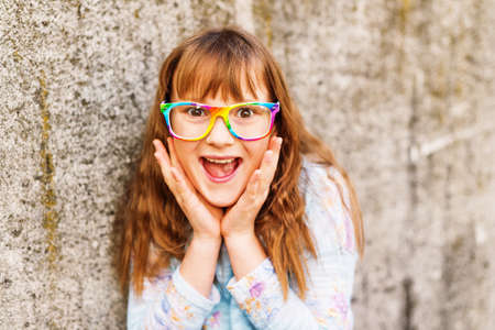 Little redhead girl wearing rainbow eyeglasses