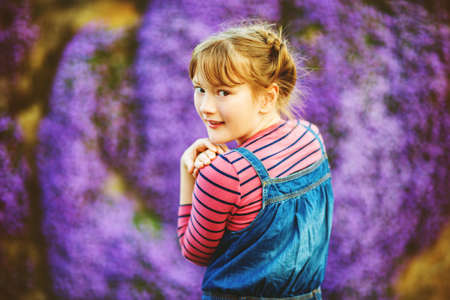 Summer portrait of young happy kid girl wearing denim overallsの写真素材