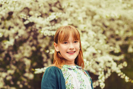 Spring portrait of young happy kid girl with red hairの写真素材