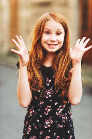 Outdoor fashion portrait of happy red-haired girlの写真素材