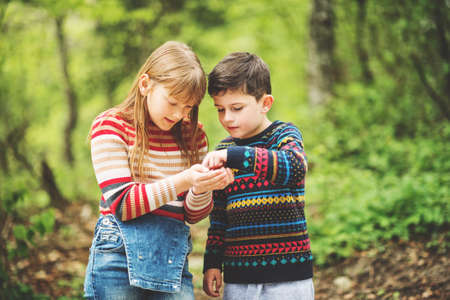Cute kids playing together in a beautiful fresh spring forestの写真素材