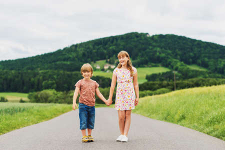 Two adorable kids playing together in summer wheat fieldの写真素材