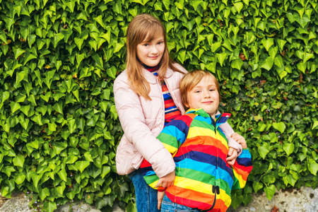 Spring portrait of adorable siblings, little boy and girl playing together outsideの写真素材