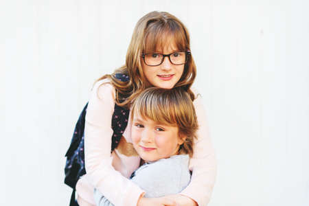 Close up portrait of two adorable kids, little boy and his big sisterの写真素材