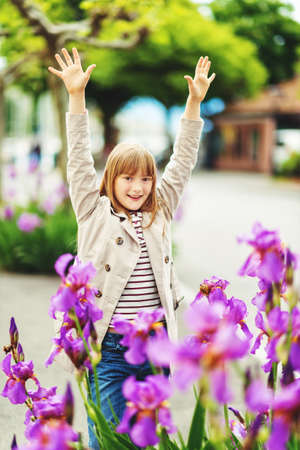 Outdoor fashion portrait of 9-10 year old hipster girl wearing stylish trench coatの写真素材