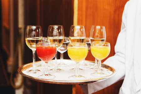 Waiter carrying tray with drinks on some festive event, party or wedding receptionの写真素材