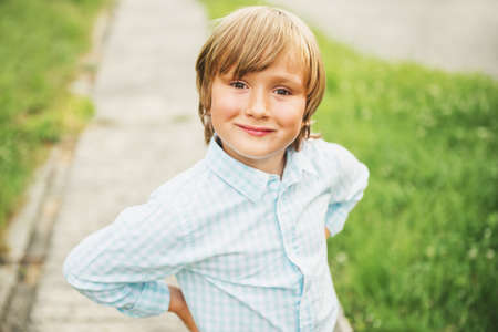 Outdoor portrait of adorable 6 year old boy wearing blue shirtの写真素材