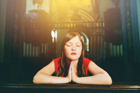 Child praying in churchの写真素材