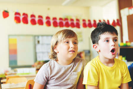 Two concentrated 4-5 year old boys in classroom