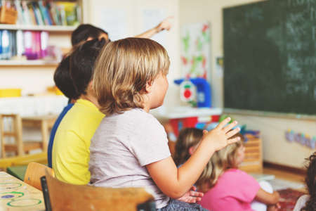 Two concentrated 4-5 year old boys in classroom