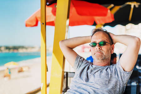 Handsome man resting at seaside beach restaurantの写真素材
