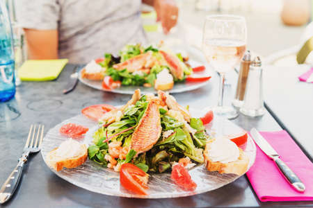 Salad provencal with red grilled snapper served in the restaurantの写真素材