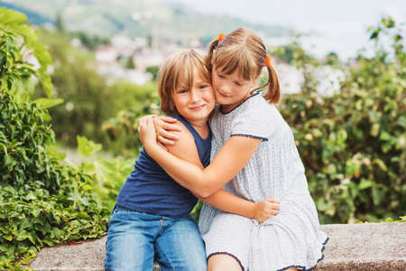 Happy little kids hugging each other, brother and sister playing together, siblings loveの写真素材
