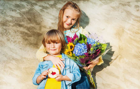 Outdoor portrait of a cute little kids with beautiful bouquet of autumn flowers.の写真素材
