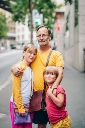 Outdoor portrait of happy family, father with kidsの写真素材