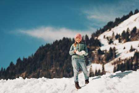 Little girl climbing the snow hill, winter vacation with children. Image taken in Valais, Switzerlandの写真素材