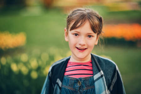 Summer portrait of young happy kid girl wearing denim overallsの写真素材