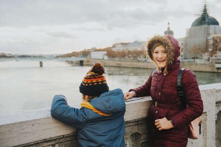 Little kids tourists admiring Rhone river from Bonaparte Bridge, Lyon, France. Travel with children....