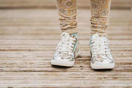 Fashion metallic laces sport shoes on kid's feetの写真素材