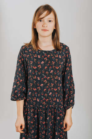 Studio shot of pretty 10 year old girl wearing black dress