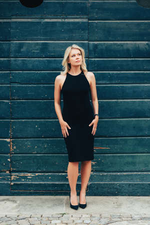 Outdoor portrait of young blond woman wearing black dressの写真素材
