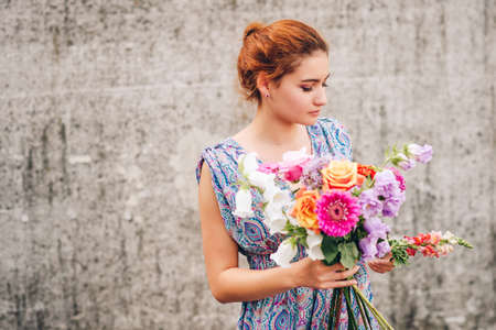 Portrait of young beautiful girl with mixed flower bouquetの写真素材