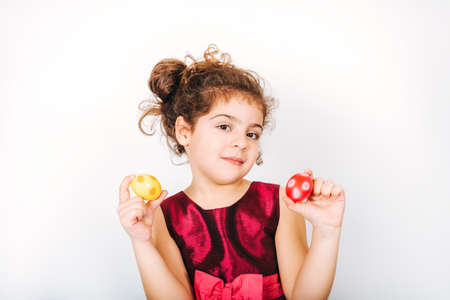 Studio shot of adorable kid girl holding colorful easter eggs