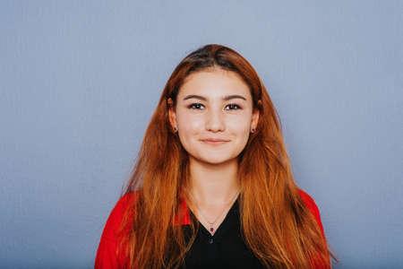 Close up portrait of young girl with red hair taken on purple backgroundの写真素材