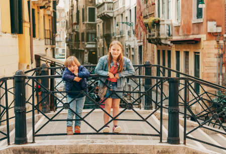 Two kids playing on the bridge in Venice. Little girl and boy visiting Venice, Italy. Small tourists in Europeの写真素材