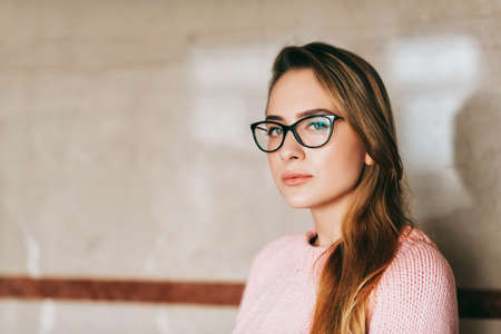 Portrait of young beautiful girl wearing glasses and pink pulloverの写真素材