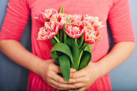 Beautiful bouquet of pink tulips in child's handsの写真素材