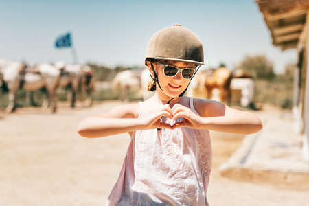 Happy little girl enjoying summer vacation in Camargue, France. Child visiting horse ranchの写真素材