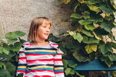Outdoor portrait of pretty kid girl wearing stripe long sleeve t-shirt
