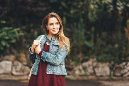 Outdoor portrait of young woman wearing denim jacket