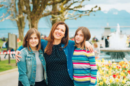 Outdoor portrait of happy mother and two young teenage girlsの写真素材