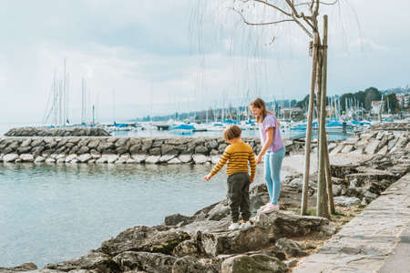 Two funny kids, little brother and sister, playing together outside by the lakeの写真素材
