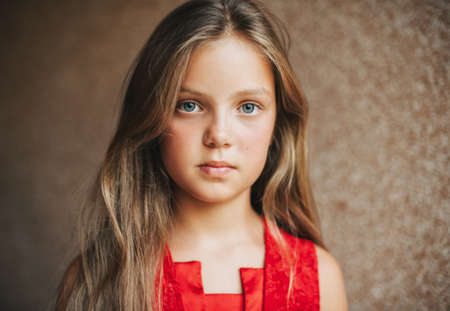 Close up portrait of cute little girl wearing red dress