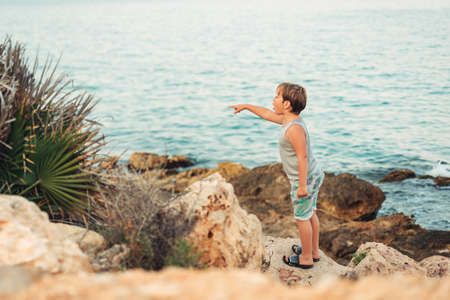 Young boy admiring sea during summer vacation in Valencia, Spain