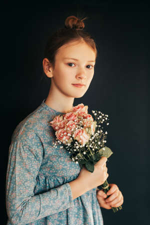 Art portrait of pretty young girl wth soft bouquet of pink rosesの写真素材