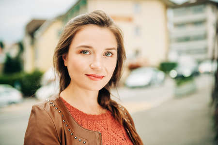 Close up portrait of beautiful young 25-30 year old woman with professional make up, wearing brown leather jacketの写真素材
