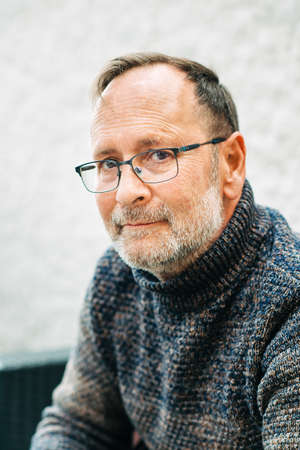 Outdoor portrait of 50 year old man wearing brown pullover and eyeglassesの写真素材