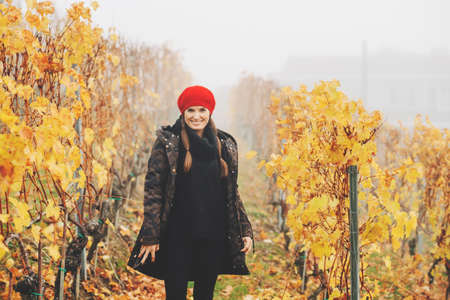Young woman hiking in Lavaux vineyards in autumn, wearing warm military jacket and red beretの写真素材