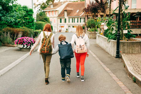 Group of 3 funny kids with backpacks, 2 schoolgirls and one preschooler, back to school conceptの写真素材