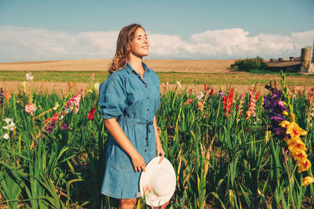 Outdoor portrait of pretty young girl in countryside, wearing denim dressの写真素材
