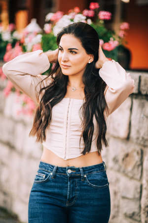 Romantic portrait of pretty young woman with long black hair, wearing pink corset blouseの写真素材