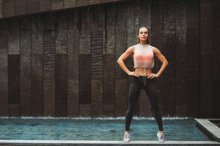 Outdoor portrait of young beautiful fit woman, wearing fashionable activewear, athlete model posing...