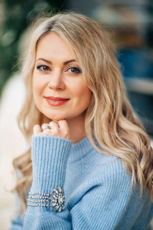Winter portrait of beautiful woman with blond hair, wearing blue pulloverの写真素材