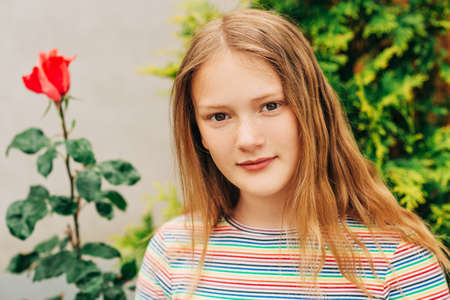 Summer portrait of pretty young girl, posing outdoors, wearing colorful tshirtの写真素材