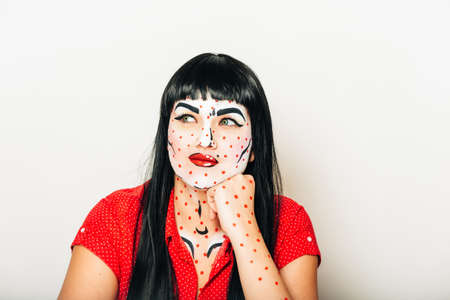 Pop art pin-up stylized studio portrait of young girl with face painting