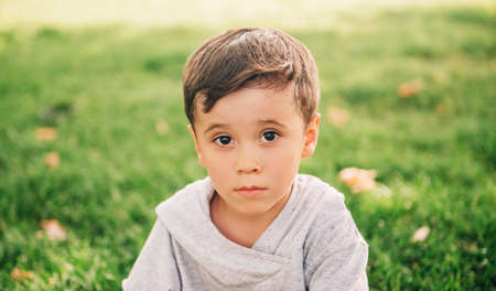 Outdoor close up portrait of adorable little boy in summer park